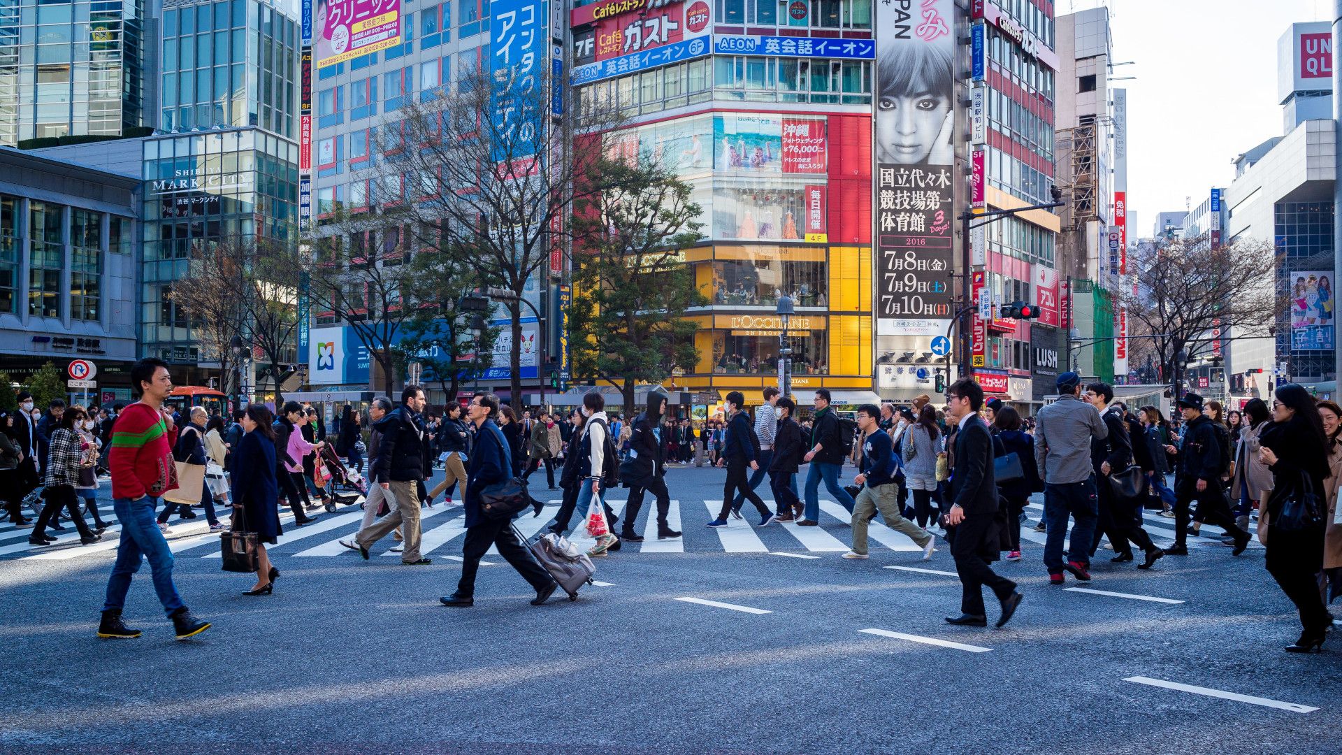 Des personnes en fin de journée traversent un carrefour à Tokyo.
